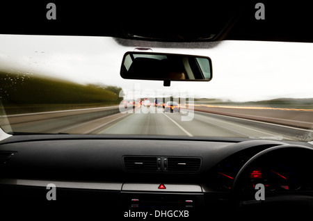 Voir à travers le pare-brise d'une voiture en mouvement avec le flou et différentes sections de l'autoroute avec les travaux routiers Voitures Camions Banque D'Images