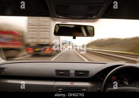 Voir à travers le pare-brise d'une voiture en mouvement avec le flou et différentes sections de l'autoroute avec les travaux routiers Voitures Camions Banque D'Images