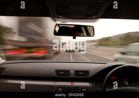 Voir à travers le pare-brise d'une voiture en mouvement avec le flou et différentes sections de l'autoroute avec les travaux routiers Voitures Camions Banque D'Images