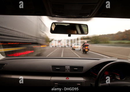 Voir à travers le pare-brise d'une voiture en mouvement avec le flou et différentes sections de l'autoroute avec les travaux routiers Voitures Camions Banque D'Images