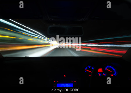 Voir à travers le pare-brise d'une voiture en mouvement avec le flou et différentes sections de l'autoroute avec les travaux routiers Voitures Camions Banque D'Images