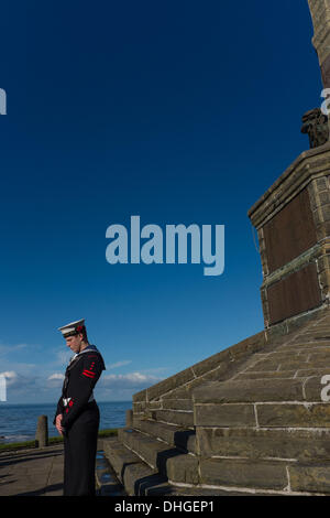 Pays de Galles Aberystwyth UK, dimanche 10 novembre 2013. Un cadet de la famille se tient sous le monument aux morts à Aberystwyth, sur Dimanche du souvenir 2013. Des centaines de personnes se sont rassemblées sur la pointe au château d'Aberystwyth pour assister à la cérémonie annuelle. Des représentants des forces armées et de nombreux groupes locaux mis à pavot rouge des couronnes à la base du monument commémoratif de guerre emblématique de la ville qui fait face à la mer. Crédit Photo © Keith morris : Keith morris/Alamy Live News Banque D'Images