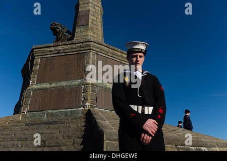 Pays de Galles Aberystwyth UK, dimanche 10 novembre 2013 un cadet de la famille se tient sous le monument aux morts à Aberystwyth, sur Dimanche du souvenir 2013. Des centaines de personnes se sont rassemblées sur la pointe au château d'Aberystwyth pour assister à la cérémonie annuelle. Des représentants des forces armées et de nombreux groupes locaux mis à pavot rouge des couronnes à la base du monument commémoratif de guerre emblématique de la ville qui fait face à la mer. Crédit Photo © Keith morris : Keith morris/Alamy Live News Banque D'Images