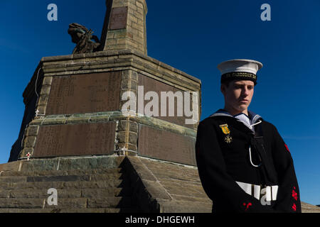 Pays de Galles Aberystwyth UK, dimanche 10 novembre 2013. Un cadet de la famille se tient sous le monument aux morts à Aberystwyth, sur Dimanche du souvenir 2013. Des centaines de personnes se sont rassemblées sur la pointe au château d'Aberystwyth pour assister à la cérémonie annuelle. Des représentants des forces armées et de nombreux groupes locaux mis à pavot rouge des couronnes à la base du monument commémoratif de guerre emblématique de la ville qui fait face à la mer. Crédit Photo © Keith morris : Keith morris/Alamy Live News Banque D'Images