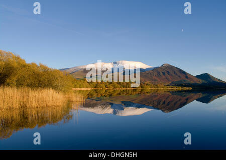 Bassenthwaite Lake, Lake District, Cumbria, Royaume-Uni, 10 novembre 2013. Les poussières de neige précoce le sommet de Las Vegas, tout en dessous de la woodland affiche toujours la couleur en automne, et un calme plat miroir donne comme réflexions sur le lac Bassenthwaite. Credit : Julie friteuse/Alamy Live News Banque D'Images