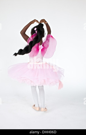 Petite fille avec de grands cheveux exécute une tresse parfaite, twirl akimbo. Banque D'Images