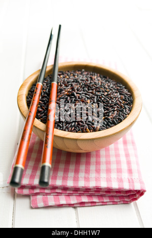 Riz noir à bol en bois avec des baguettes Banque D'Images