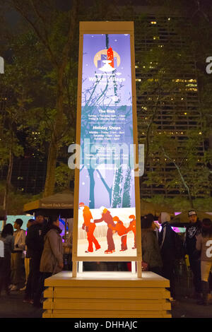 Manhattan, New York, États-Unis Le 9 novembre 2013. Visiteurs patin à glace et boutique dans les magasins de vacances annuelles, au Village d'hiver patinoire au Bryant Park de nuit. © Ann E Parry/Alamy Live News Banque D'Images