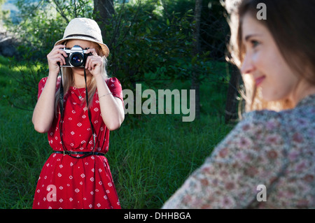 Young woman taking photograph of friend Banque D'Images