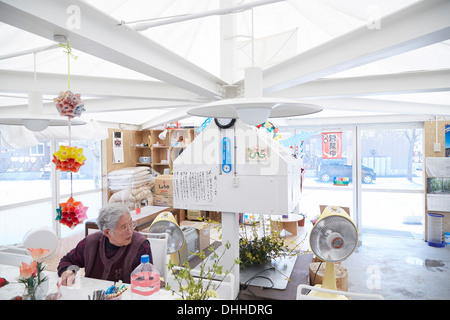 La maison pour tous- Kamaishi, Kamaishi, au Japon. Architecte : Riken Yamamoto, 2013. 'Accueil pour tous" - Intérieur avec vieille dame. Banque D'Images