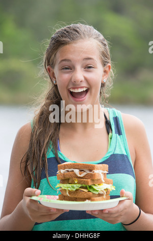 Portrait of teenage girl holding sandwich Banque D'Images