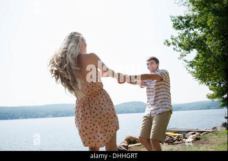 Young couple holding hands by lake Banque D'Images