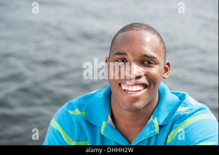 Portrait of young man wearing blue polo, smiling Banque D'Images