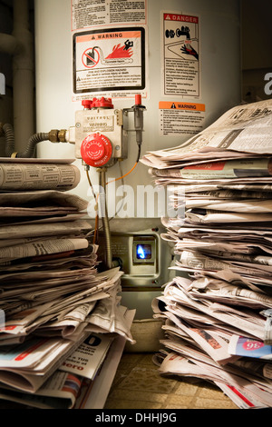 Des piles de journaux à côté de chaudière à gaz allumé Banque D'Images