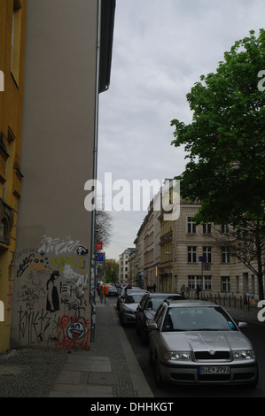 Ciel gris portrait des voitures en stationnement, graffit scrawl, 'Xooox' fashion model stencil sur la construction de mur, la Grosse Hamburger Strasse, Berlin Banque D'Images