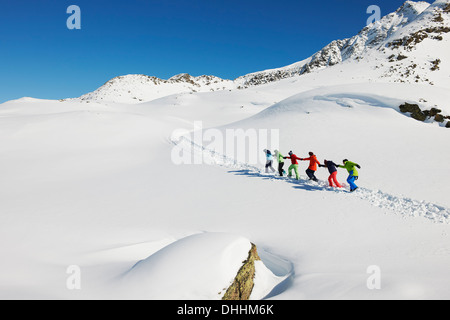 Les amis d'autres tirant chaque montée dans la neige, Kuhtai, Autriche Banque D'Images