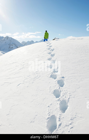 Homme debout dans la neige avec des empreintes, Kuhtai, Autriche Banque D'Images