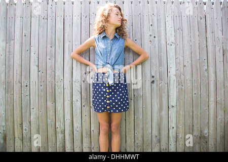 Portrait of teenage girl en face de clôture en bois Banque D'Images