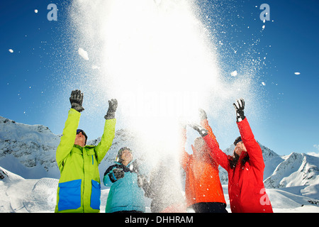Les amis throwing snow mid air, Kuhtai, Autriche Banque D'Images