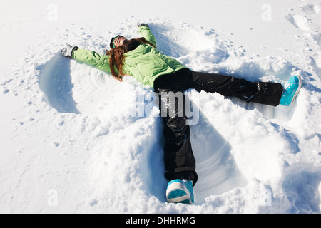 Young woman making snow angel, Kuhtai, Autriche Banque D'Images