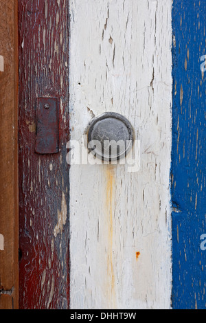 Grumes de rouge, blanc et bleu de la peinture sur une course vers le bas des portes beach hut Banque D'Images