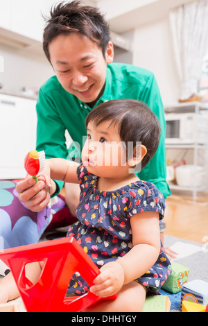 Père jouer avec bébé sur marbre Banque D'Images