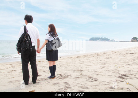 Young couple holding hands on beach, vue arrière Banque D'Images