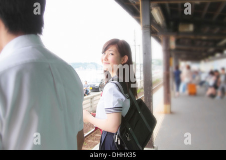 Jeune femme sur un quai de gare looking at camera Banque D'Images