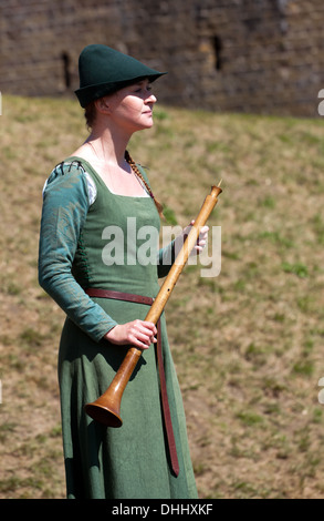 Femme dans un costume d'un instrument à vent holding médiévale, au château de Douvres, dans le Kent. Banque D'Images