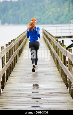 Woman jogging le pier, Bainbridge Island, Washington, USA Banque D'Images