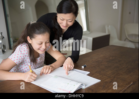 Mother helping teenage daughter with Homework Banque D'Images