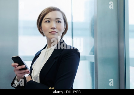 Portrait of young woman holding cell phone Banque D'Images