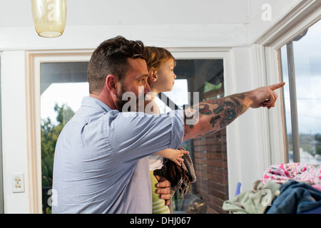 Père et fille à la recherche d'une fenêtre Banque D'Images