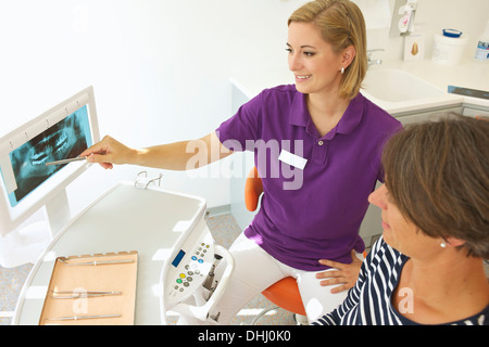 Dentist showing patient xray d'implants dentaires Banque D'Images