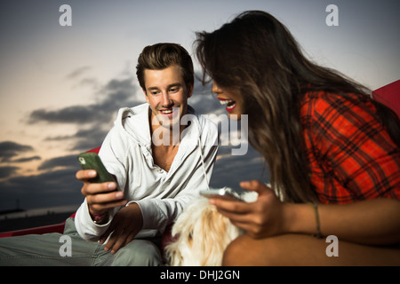 Jeune couple avec téléphone cellulaire, San Diego, California, USA Banque D'Images