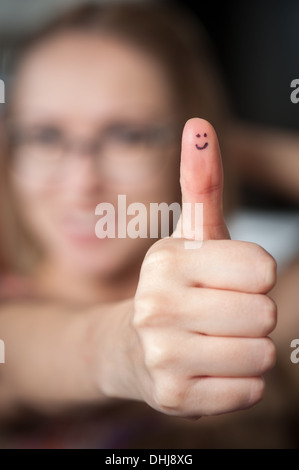 Jolie femme avec des sourires sur le pouce giving Thumbs up Banque D'Images