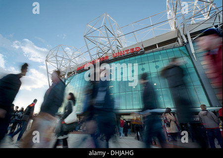 Fans de Manchester United Football Club de marche passé le grand verre avant du club stade Old Trafford (usage éditorial uniquement). Banque D'Images