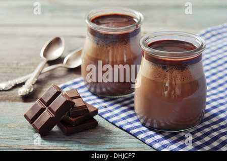 Panna cotta au chocolat dans des bocaux en verre sur fond de bois Banque D'Images