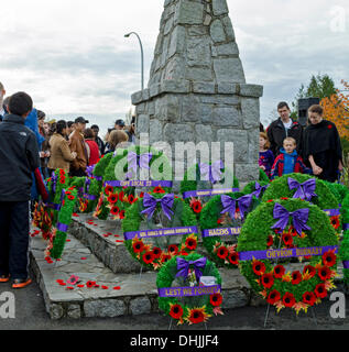 BURNABY, Colombie-Britannique, Canada - Lundi 11 Novembre 2013 : personnes regardant les guirlandes et coquelicots qui avait été placée sur le centotaph au cours de la cérémonie du Jour du Souvenir tenue au Parc de la Confédération, Burnaby, BC. Le Canada. Banque D'Images