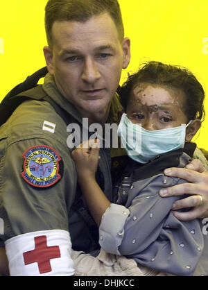 Banda Aceh, Indonésie, . 4 janvier, 2005. Le LIEUTENANT MARK RIVES DU PORTE-AVIONS ABRAHAM LINCOLN EST ÉMOTIONNEL COMME IL BERCEAUX UN GRAVEMENT BLESSÉ ET EFFRAYÉ ACEHIAN FILLE QUI EST DÉPLACÉ D'UN VÉHICULE DE TRANSPORT MILITAIRE POUR ÊTRE MEDIVACCED À MEDAN POUR TRAITEMENT, 04 janvier 2005. © Stephen Shaver/ZUMAPRESS.com/Alamy Live News Banque D'Images