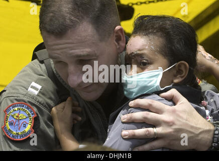 Banda Aceh, Indonésie, . 4 janvier, 2005. Le LIEUTENANT MARK RIVES DU PORTE-AVIONS ABRAHAM LINCOLN EST ÉMOTIONNEL COMME IL BERCEAUX UN GRAVEMENT BLESSÉ ET EFFRAYÉ ACEHIAN FILLE QUI EST DÉPLACÉ D'UN VÉHICULE DE TRANSPORT MILITAIRE POUR ÊTRE MEDIVACCED À MEDAN POUR TRAITEMENT, 04 janvier 2005. © Stephen Shaver/ZUMAPRESS.com/Alamy Live News Banque D'Images