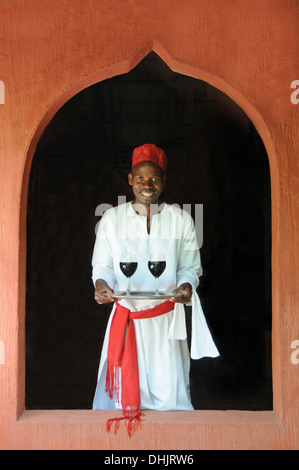 Un garçon porte deux verres de vin rouge. Archipel de Bazaruto, Benguerra Island. Le Mozambique. L'Afrique de l'Est. Banque D'Images