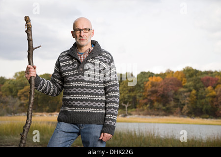 Mature man holding a stick Banque D'Images