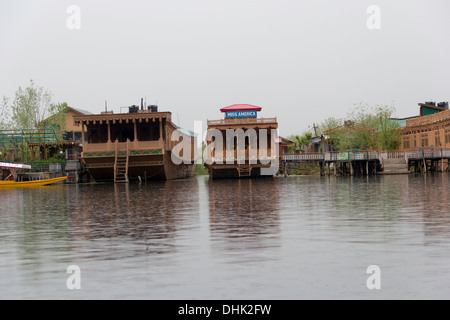 Péniches le long avec un shikara sur le lac Dal à Srinagar, au Cachemire, en Inde. Les touristes aiment rester dans ces grands bateaux en bois Banque D'Images