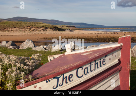 Village de Brora, Ecosse. Vue pittoresque sur un vieux bateau sur les rives de Brora avec la mer du Nord à l'arrière-plan. Banque D'Images