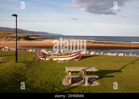 Village de Brora, Ecosse. Vue pittoresque sur un vieux bateau sur les rives de Brora avec la mer du Nord à l'arrière-plan. Banque D'Images