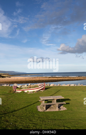 Village de Brora, Ecosse. Vue pittoresque sur un vieux bateau sur les rives de Brora avec la mer du Nord à l'arrière-plan. Banque D'Images