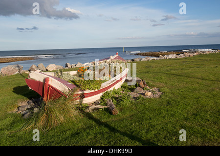 Village de Brora, Ecosse. Vue pittoresque sur un vieux bateau sur les rives de Brora avec la mer du Nord à l'arrière-plan. Banque D'Images