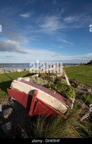 Village de Brora, Ecosse. Vue pittoresque sur un vieux bateau sur les rives de Brora avec la mer du Nord à l'arrière-plan. Banque D'Images