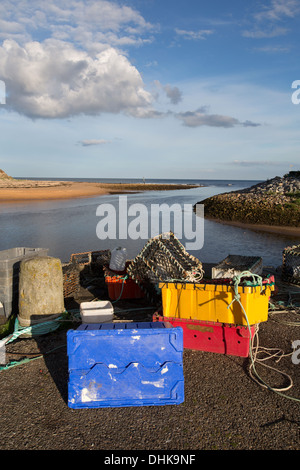 Village de Brora, Ecosse. Vide des caisses à poisson et des casiers à homard à Brora port avec la mer du Nord à l'arrière-plan. Banque D'Images